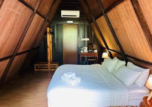 a bedroom with a bed with two towels on it at Rustcamps Glamping Resort in Genting Highlands