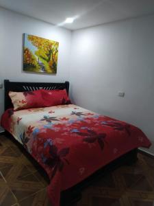 Schlafzimmer mit einem Bett mit einer roten Bettdecke in der Unterkunft Habitación Amplia cerca al Éxito de la Cra 27 in Barranquilla