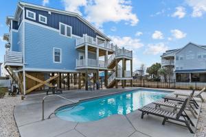 een blauw huis met een zwembad en een terras bij A New Hope in Oak Island
