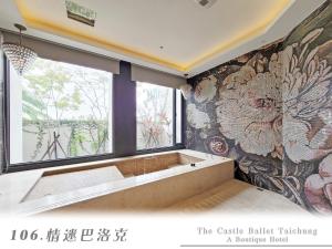 a bathroom with a bath tub and a large window at The Castle Ballet Taichung A Boutique Hotel in Taichung