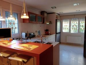 瓦伦西亚Experience Valencia Luxury Chalet Puig Val con piscina的房间里有一张桌子和几把椅子的厨房
