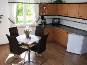 a kitchen with a table and chairs in a kitchen at Holiday apartment in the Saxon Switzerland National Park in Lichtenhain