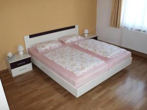 ein Schlafzimmer mit einem großen Bett mit rosa Bettwäsche und Kissen in der Unterkunft Holiday apartment in the Saxon Switzerland National Park in Lichtenhain