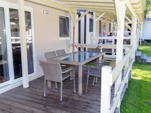 a patio with a table and chairs on a porch at Mobile Home Bodensdorf near Lake Ossiach in Tratten
