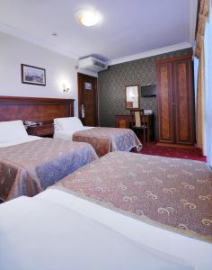 a hotel room with three beds and a television at Grand Eyuboglu Hotel in Istanbul +12 photos
