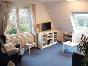 una pequeña sala de estar con TV y sofá en Apartment in Lower Saxony, en Halstenbek