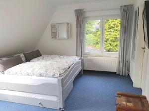 1 dormitorio con cama blanca y ventana en Apartment in Lower Saxony, en Halstenbek
