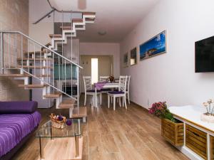 a living room with a spiral staircase and a dining room at Apartments House Đurđica in Bol