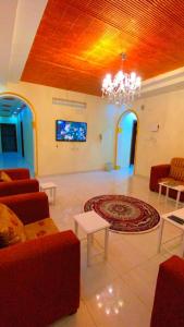 un soggiorno con lampadario pendente, divano e tappeto di Madinah Daylight Residences a Medina