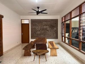 um quarto com um banco e uma ventoinha de tecto em Wijaya Hostel em Denpasar