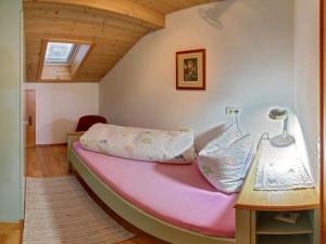 a large pink bed in a room with a table at Staufenblick roof studio in the house in Inzell