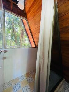 a bathroom with a window and a shower with a shower curtain at Chalet Cerro azul in Cerro Azul