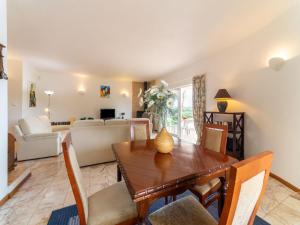 a dining room and living room with a table and chairs at Comfortable house with garden and swimming pool 