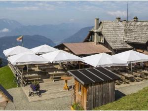 TrattenにあるBungalow in Bodensdorf near Gerlitzen Ski Areaの山の上にテーブルと白傘を備えたレストラン