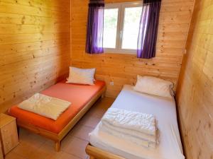 TrattenにあるBungalow in Bodensdorf near Gerlitzen Ski Areaのログキャビン内のベッド2台が備わる部屋です。