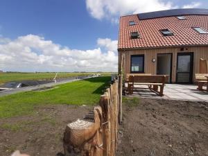 un bâtiment en bois avec un banc et une clôture dans l'établissement Wheelchair accessible villa in Friesland, à Leons