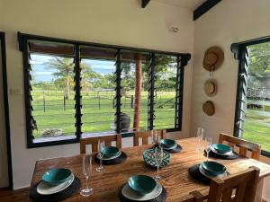 uma sala de jantar com uma mesa de madeira e uma grande janela em Tobu House em Savusavu