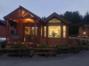 a wooden cabin with a large front porch at Odysea Ocean Cabin 26 w Jacuzzi & Modern Decor in Smith River