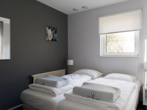 een slaapkamer met 2 bedden met witte lakens en een raam bij Family house with sauna, outdoor spa and sloop in Earnewâld