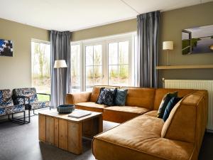 uma sala de estar com um sofá e uma mesa em Family house with sauna, outdoor spa and sloop em Earnewâld