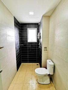 a bathroom with a toilet and a window at EcoPark Condo, 5mins to airport, malls & eatery in Miri