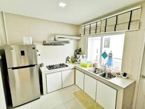uma cozinha com um frigorífico e um lavatório em EcoPark Condo, 5mins to airport, malls & eatery em Miri