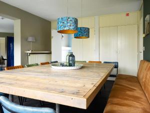 uma sala de jantar com uma mesa de madeira e cadeiras em Family house with sauna, outdoor spa and sloop em Earnewâld