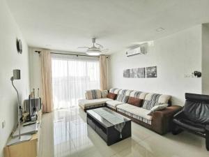 ein Wohnzimmer mit einem Sofa und einem TV in der Unterkunft EcoPark Condo, 5mins to airport, malls & eatery in Miri