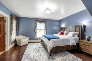 a blue bedroom with a bed and a chair at Stay In A Piece of San Jose History. in San Jose