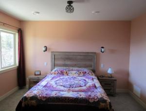 ein Schlafzimmer mit einem großen Bett und einem Fenster in der Unterkunft Okanagan Lake Sunrise BB in Vernon