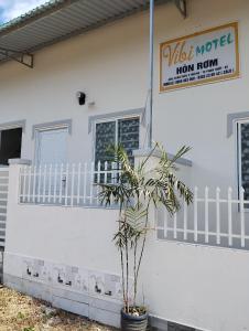 une maison blanche avec une plante devant elle dans l'établissement Vibi motel, à Phan Thiết
