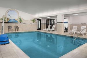 uma grande piscina com cadeiras e cadeiras num hotel em Hampton Inn Easton em Easton