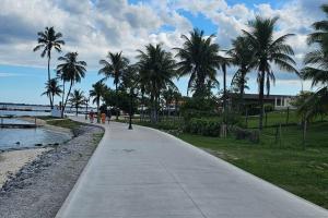 a walking path next to the beach with palm trees at Imóvel com piscina e execelente estrutura ! in Araruama