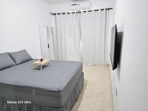 a bedroom with a bed and a flat screen tv at Imóvel com piscina e execelente estrutura ! in Araruama