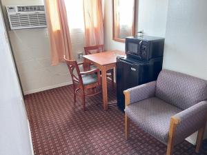 a small room with a table and a tv and a chair at Royal A Motel in Auburn