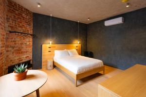 a bedroom with a bed and a brick wall at In The Brick Spa And Hotel in Melbourne