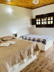 ボニートにあるPousada e Restaurante Alto da Serraのベッド2台が隣同士に設置された部屋です。