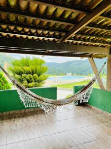 a hammock on a patio with a view of a pool at Pousada e Restaurante Alto da Serra in Bonito