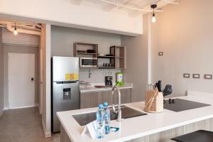 a kitchen with a sink and a refrigerator at Cayalá Lofts in Guatemala