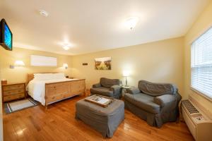 1 dormitorio con 1 cama, 2 sillas y escritorio en Aurora Park Cottages en Calistoga