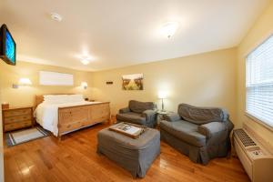 a bedroom with a bed and two chairs and a desk at Aurora Park Cottages in Calistoga