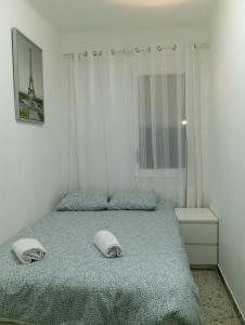 una camera con un letto con due cuscini sopra di Room Familiar nube paraiso a Barcellona