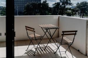 2 stoelen en een tafel op een balkon bij Urban 1-Bed Apartment in the Heart of the City in Canberra
