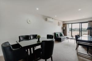 een woonkamer met een eettafel en stoelen bij Urban 1-Bed Apartment in the Heart of the City in Canberra