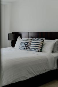 een groot wit bed met 2 kussens erop bij Urban 1-Bed Apartment in the Heart of the City in Canberra