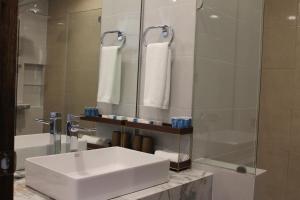 y baño con lavabo blanco y ducha. en Magarra Hotel en Orani
