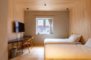 Zimmer mit 2 Betten, einem Schreibtisch und einem Fenster in der Unterkunft In The Brick Spa And Hotel in Melbourne