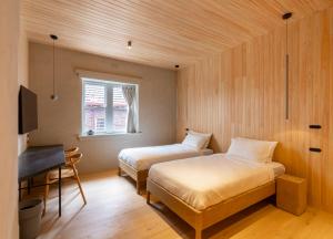 墨尔本In The Brick Spa And Hotel的一间卧室，配有两张床、一张书桌和一台电视