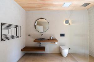 a bathroom with a toilet and a mirror at In The Brick Spa And Hotel in Melbourne