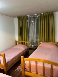 2 camas en una habitación con cortinas verdes en Departamento Amoblado Full Equipado en Santiago